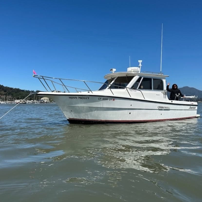 Miss Molly, a white pilothouse boat, on the water