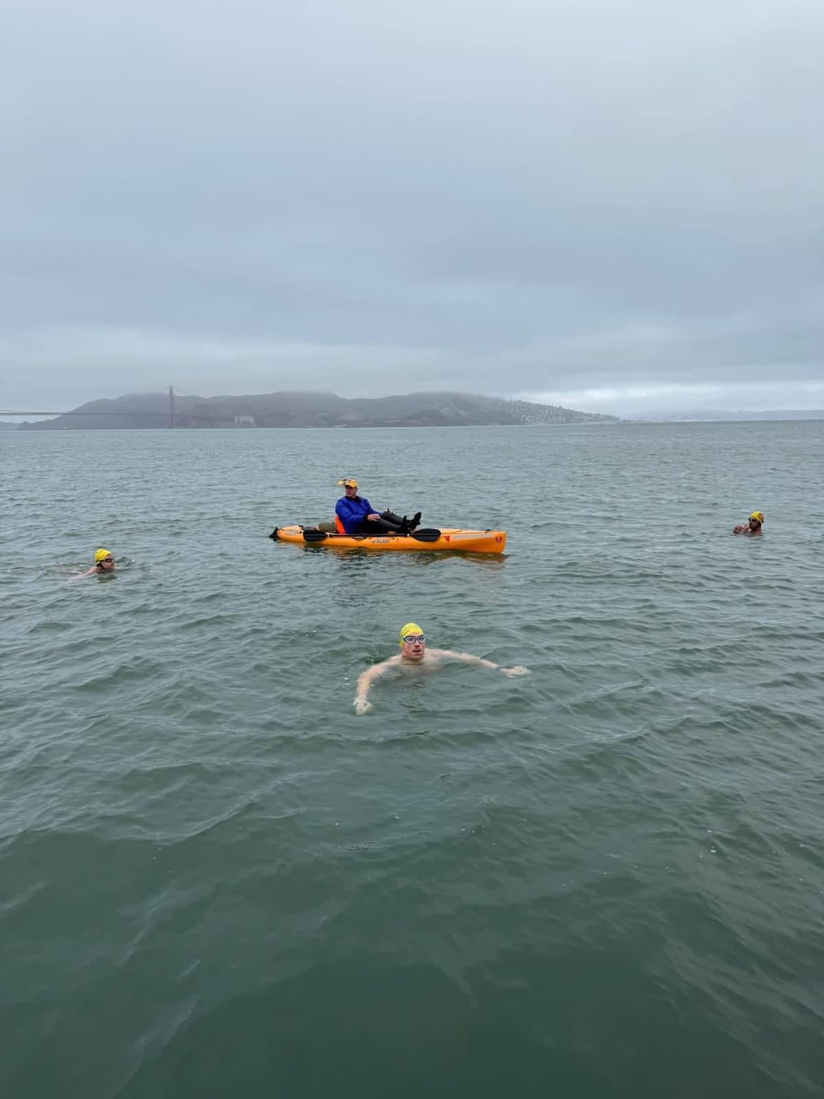 Open-water swimmers and a kayaker on San Francisco Bay
